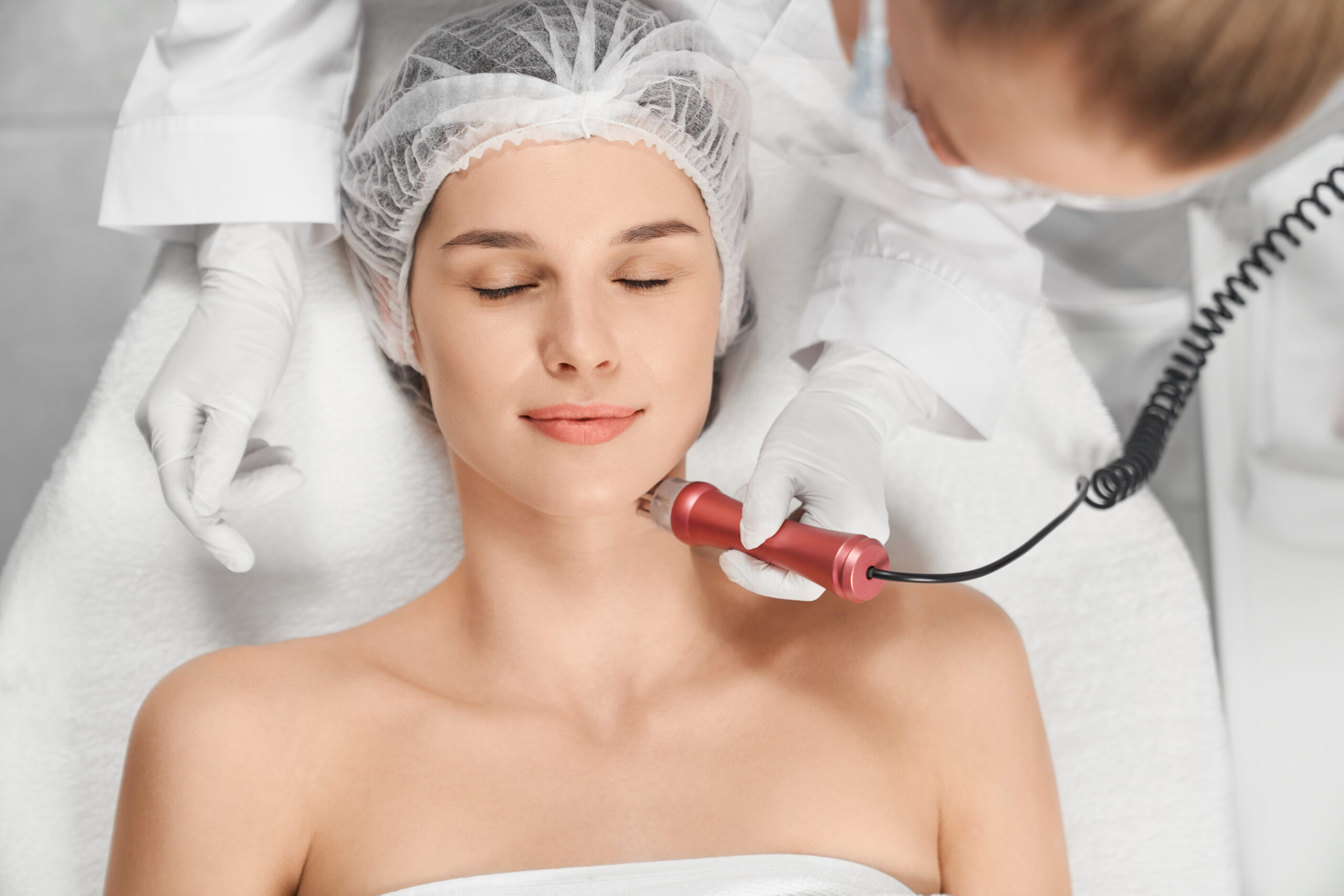 Woman Enjoying Procedure Cleaning Or Massage For Face.